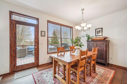dining area featuring a chandelier, a textured ceiling, wood finished floors, and baseboards