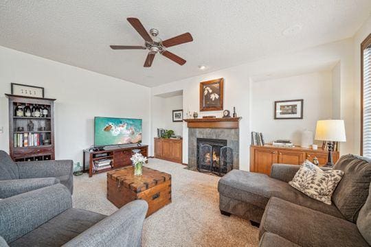 living room with carpet floors, a fireplace, and ceiling fan