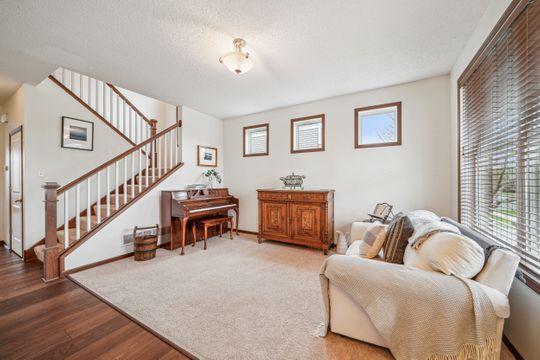 living room featuring plenty of natural light, stairway, wood finished floors, and baseboards