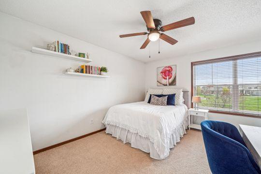 bedroom featuring light colored carpet, baseboards, and a ceiling fan