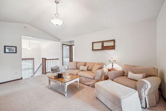 living room with vaulted ceiling, carpet floors, and a textured ceiling
