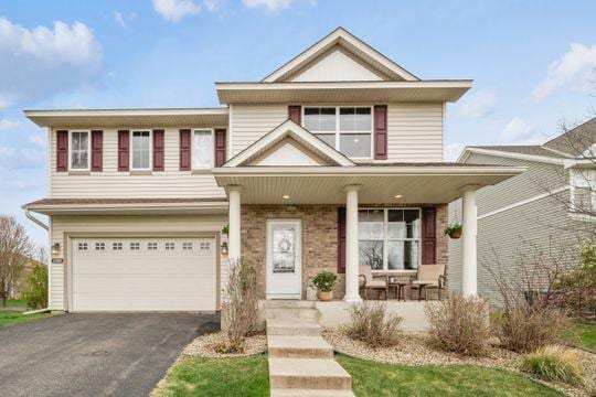 view of front of house with a porch, a garage, and asphalt driveway