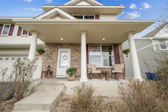 doorway to property featuring a porch and brick siding