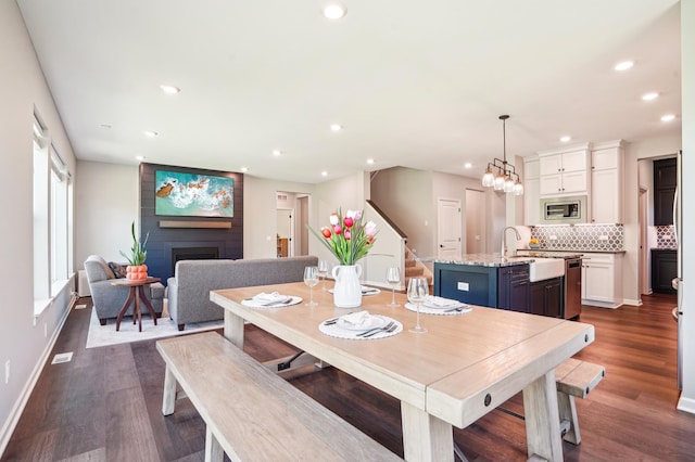 11504 Yuma Ln N, Dayton, MN 55369 - dining area with a fireplace, dark wood-style floors, recessed lighting, stairway, and baseboards