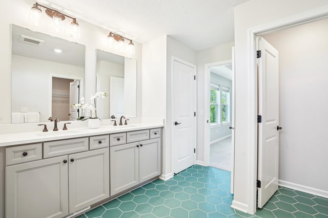 11504 Yuma Ln N, Dayton, MN 55369 - bathroom with double vanity, baseboards, tile patterned floors, and a textured ceiling
