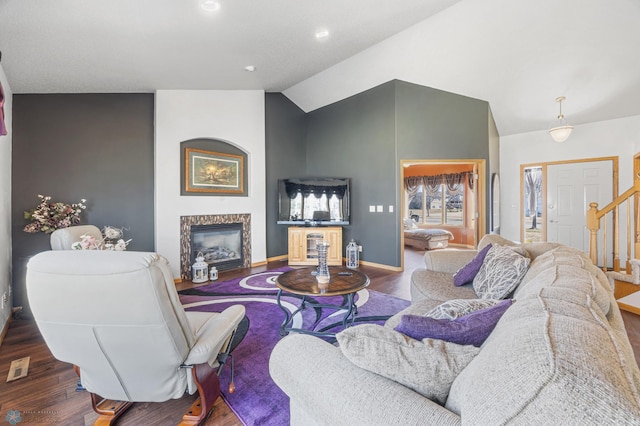 living room with stairs, wood finished floors, baseboards, vaulted ceiling, and a premium fireplace