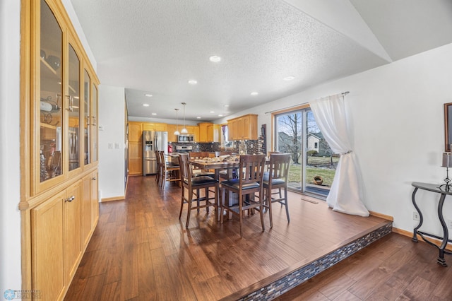 dining area with recessed lighting, a textured ceiling, baseboards, and dark wood-type flooring