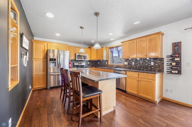 kitchen with decorative backsplash, a textured ceiling, dark countertops, and stainless steel appliances