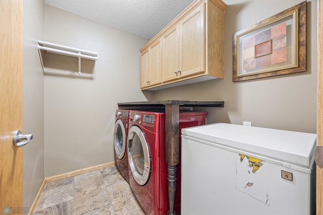 laundry room with baseboards, stone finish floor, washer and clothes dryer, a textured ceiling, and cabinet space