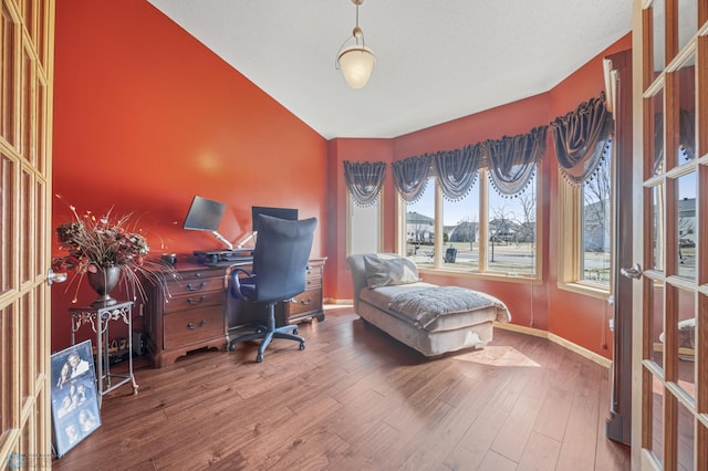 home office featuring baseboards, vaulted ceiling, and wood finished floors