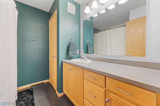 bathroom featuring vanity, baseboards, and visible vents
