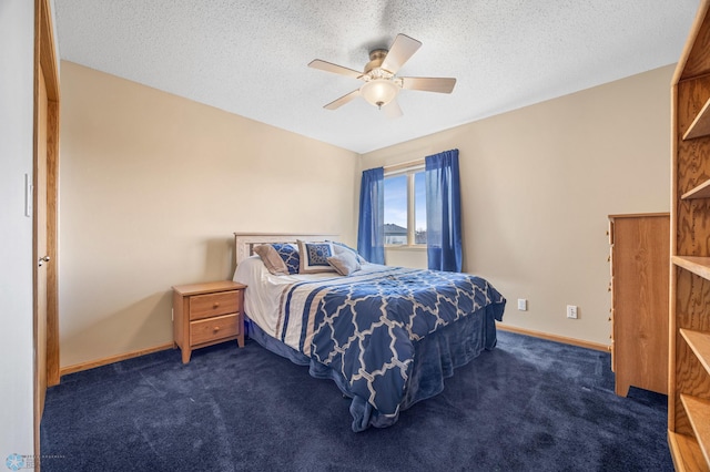 bedroom featuring baseboards, dark colored carpet, and a textured ceiling