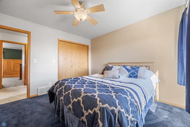 carpeted bedroom with baseboards, ceiling fan, a closet, and visible vents