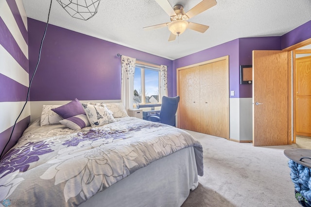 bedroom with a textured ceiling, ceiling fan, carpet, and a closet
