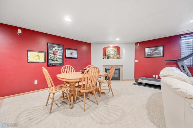 carpeted dining space featuring recessed lighting, baseboards, and a tiled fireplace
