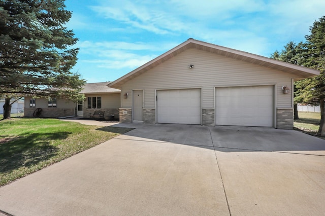 ranch-style home with a detached garage and a front lawn