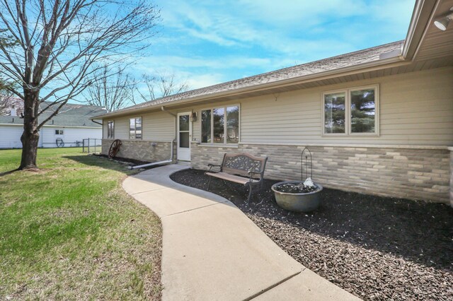 entrance to property with a yard and brick siding