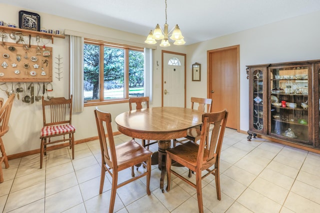 dining space with light tile patterned floors, a chandelier, and baseboards