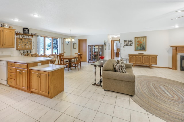 kitchen featuring light tile patterned floors, white dishwasher, a peninsula, light countertops, and open floor plan