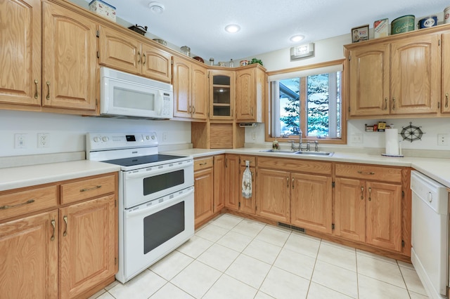 kitchen featuring light tile patterned floors, visible vents, a sink, and white appliances
