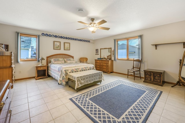 bedroom with light tile patterned floors, ceiling fan, and baseboards