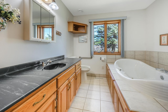full bath with vanity, tile patterned floors, toilet, baseboards, and a jetted tub