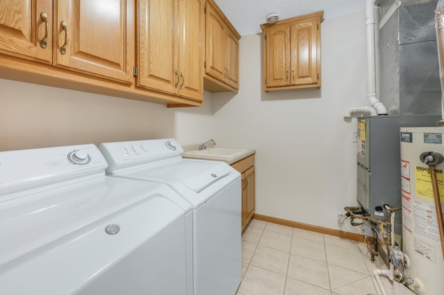 clothes washing area with gas water heater, a sink, light tile patterned floors, washing machine and dryer, and baseboards