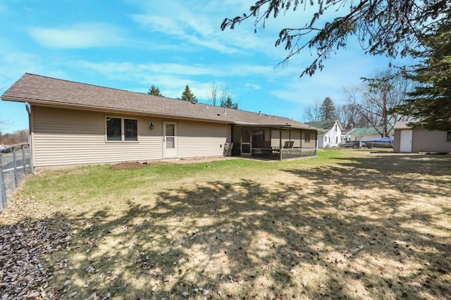 back of house featuring a sunroom, a yard, and a fenced backyard