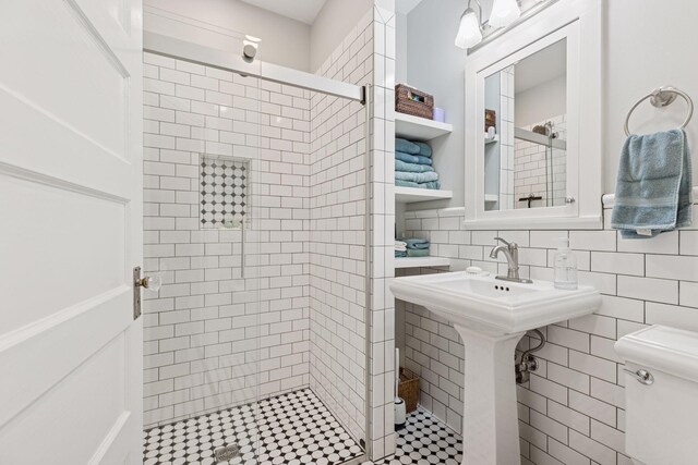 bathroom featuring tile walls, a shower stall, and toilet