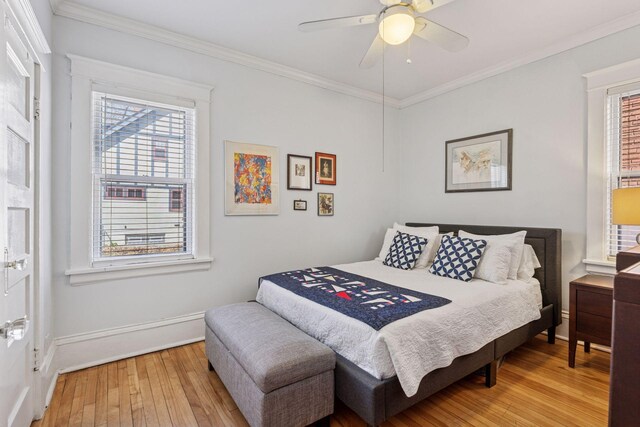 bedroom featuring baseboards, ornamental molding, light wood-style flooring, and ceiling fan
