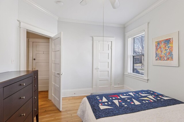 bedroom featuring light wood-type flooring, ornamental molding, baseboards, and a ceiling fan