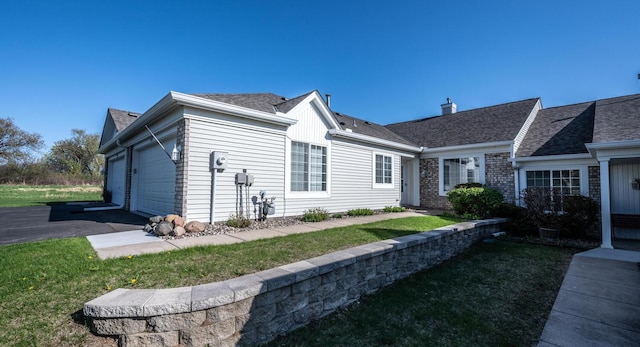 view of front of home featuring a garage, a front yard, a shingled roof, and asphalt driveway
