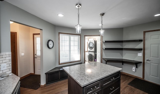 kitchen featuring stacked washing machine and dryer, dark wood-style floors, baseboards, decorative light fixtures, and recessed lighting