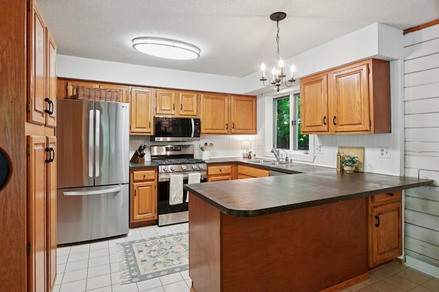3021 Devon Ln, Mound, MN 55364 - kitchen featuring appliances with stainless steel finishes, dark countertops, a sink, a peninsula, and light tile patterned floors