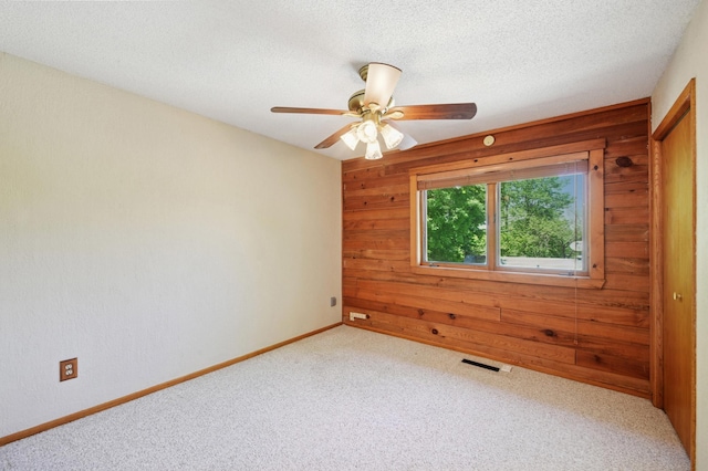 3021 Devon Ln, Mound, MN 55364 - carpeted empty room featuring wooden walls, ceiling fan, a textured ceiling, and baseboards