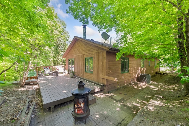 3021 Devon Ln, Mound, MN 55364 - view of side of property featuring an outdoor fire pit, a wooden deck, central AC unit, and a patio area