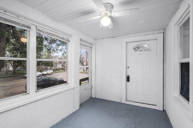 unfurnished sunroom featuring a ceiling fan