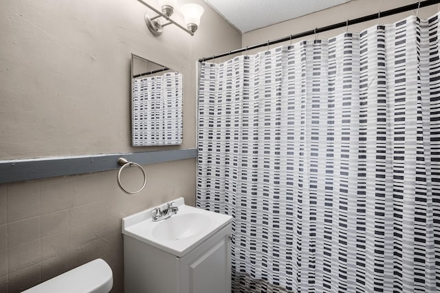 bathroom featuring vanity, toilet, and a textured ceiling