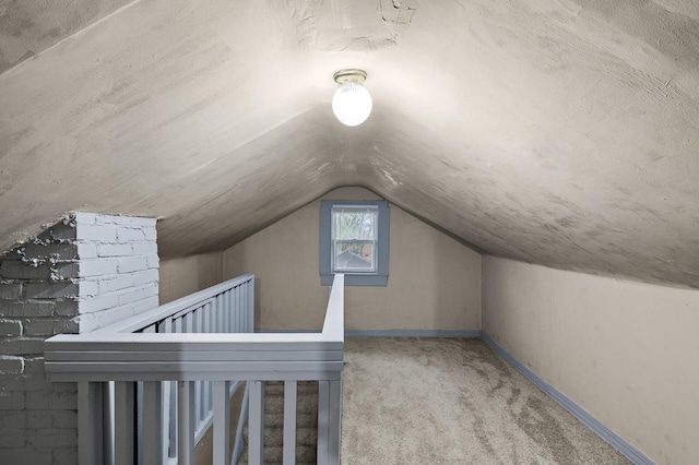additional living space featuring carpet floors, baseboards, and lofted ceiling