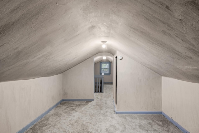 additional living space with carpet floors, baseboards, and lofted ceiling