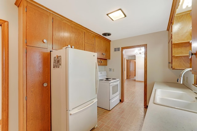 kitchen with visible vents, a sink, light countertops, brick patterned floor, and white appliances