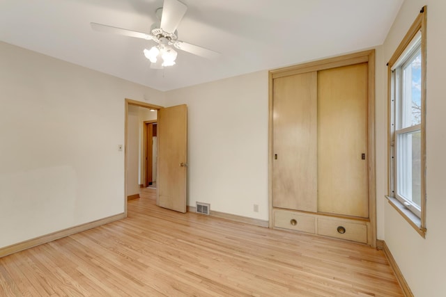 spare room featuring ceiling fan, visible vents, baseboards, and light wood-style floors