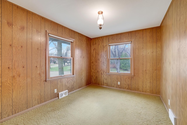 carpeted spare room with plenty of natural light and visible vents