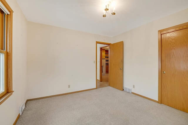 unfurnished bedroom with baseboards, carpet flooring, and visible vents