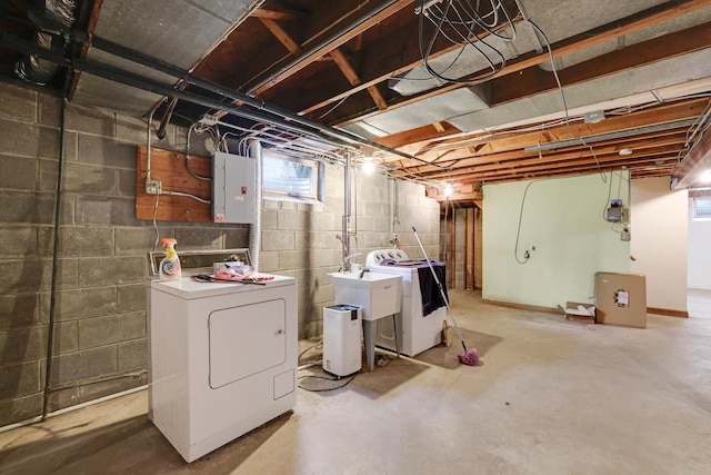 basement featuring a sink, washing machine and dryer, and electric panel