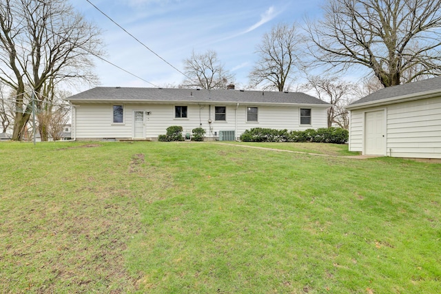 rear view of property featuring a yard and central AC