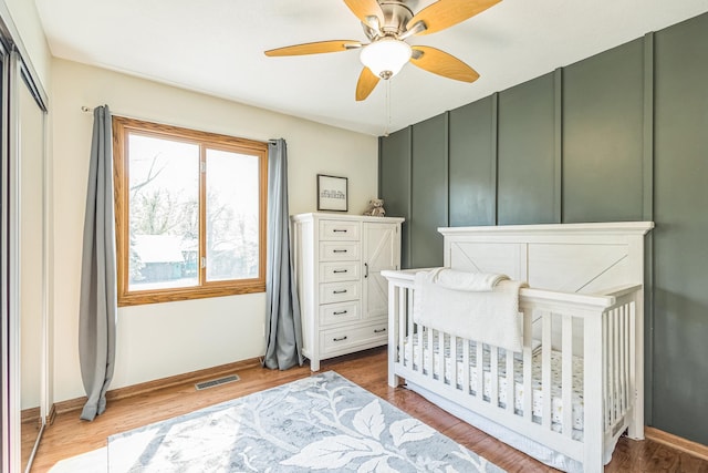 12720 Parkwood Dr, Burnsville, MN 55337 - bedroom featuring wood finished floors, ceiling fan, a crib, and baseboards