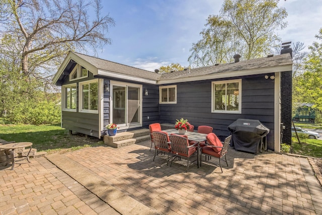 12720 Parkwood Dr, Burnsville, MN 55337 - rear view of house featuring entry steps, a patio area, a chimney, and outdoor dining space
