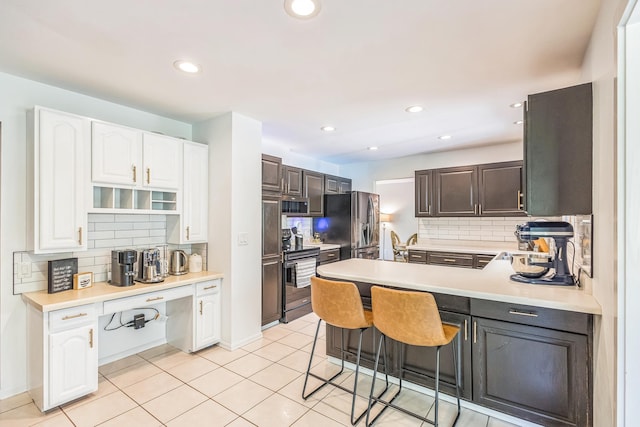 12720 Parkwood Dr, Burnsville, MN 55337 - kitchen with appliances with stainless steel finishes, backsplash, white cabinets, a kitchen breakfast bar, and recessed lighting