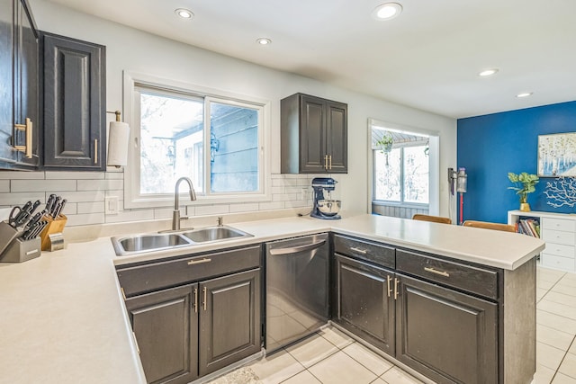 12720 Parkwood Dr, Burnsville, MN 55337 - kitchen featuring dishwasher, a sink, a peninsula, light tile patterned floors, and light countertops